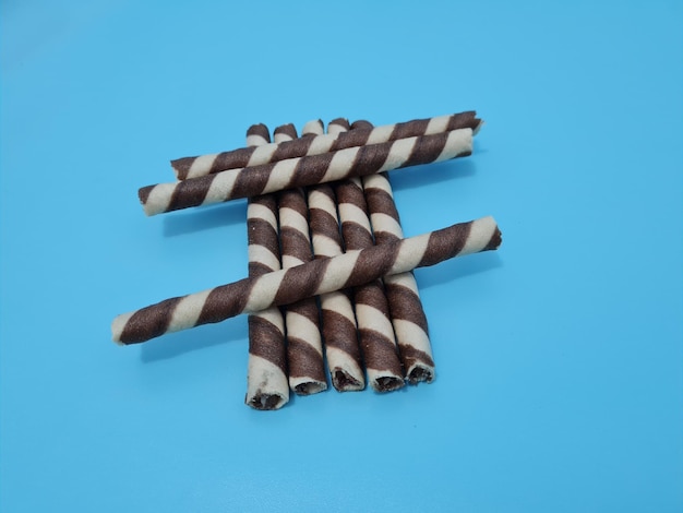 Chocolate wafer rolls on a blue background top view