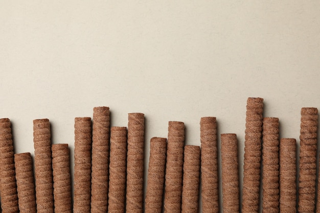 Chocolate wafer rolls on gray background, top view