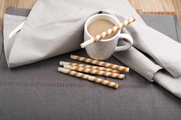 Chocolate Wafer Sticks and Cup of Coffee with Milk on Gray Background