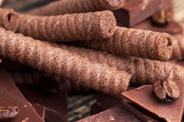 Chocolate waffle tubes with chocolate filling and pieces of homemade chocolate