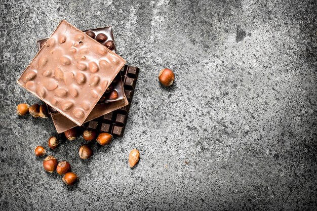 Chocolate with nuts on rustic table.