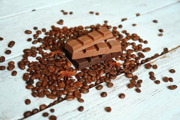 Chocolate with star anise and coffee beans on wooden background