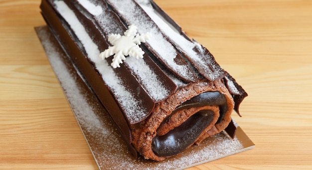 Chocolate Yule Log Christmas Cake or Buche de Noel on Wooden Table
