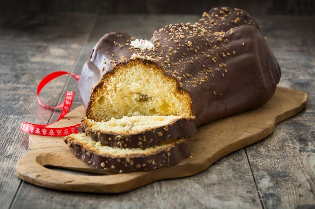 Torta di natale del ceppo del yule del cioccolato ed ornamento di natale su di legno