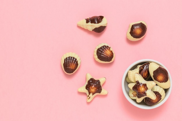 Chocolates in the form of sea shellfish and shells. The sweetness of milk chocolate. The view from the top. Flat lay.