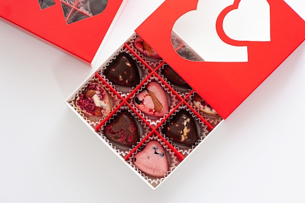 Chocolates, hearts with berries, handmade in a beautiful red cardboard box, close-up