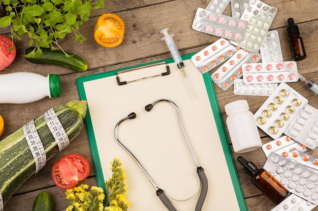 The choice between a healthy lifestyle and medications Vegetables or pills clipboard stethoscope