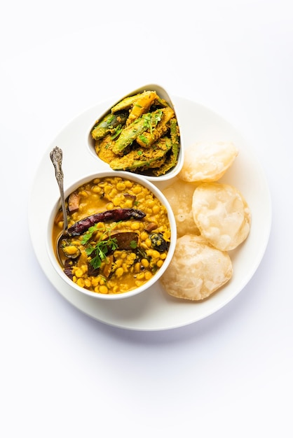 Cholar dal en patol aloo sabzi geserveerd met gebakken Luchi of poori Bengali eten