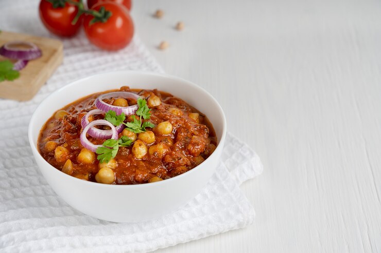 Chole masala 인도 채식 음식은 chickpeas와 테이블에 수건에 다진 토마토로 만든
