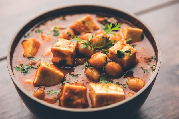 Карри Chole Paneer из отварного нута с творогом и специями. Популярный рецепт в Северной Индии. подается в миске или сервировочном сковороде. Выборочный фокус