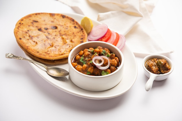 Photo chole with aloo paratha popular north indian food recipe served hot with mango pickle