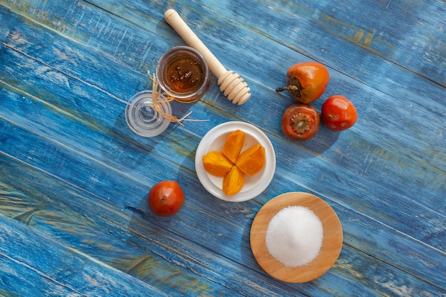 Chontaduro, exotisch tropisch fruit, gesneden met zout en honing naast rauwe chontaduros op een rustieke blauwe houten tafel. Bactris gasipaes, Bovenaanzicht