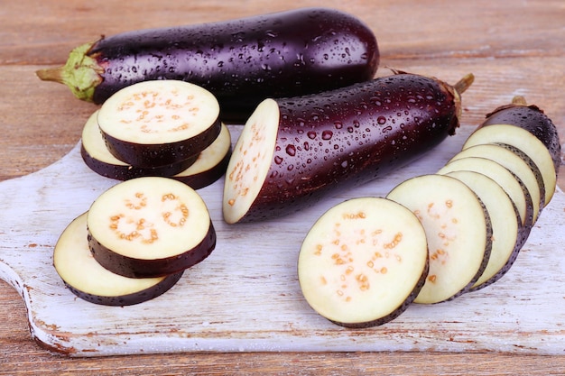 Chopped aubergines on cutting board on wooden background