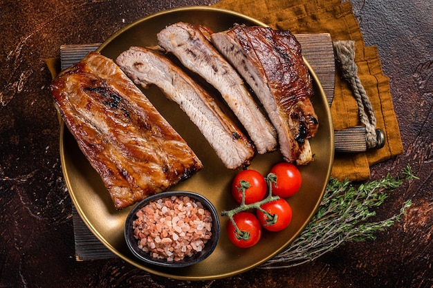 Chopped BBQ pork ribs  on a plate with herbs Dark background Top view