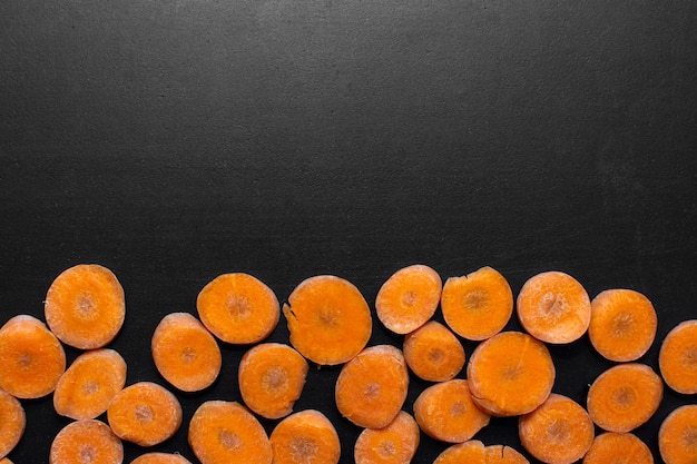 chopped carrots on a black table with space for text