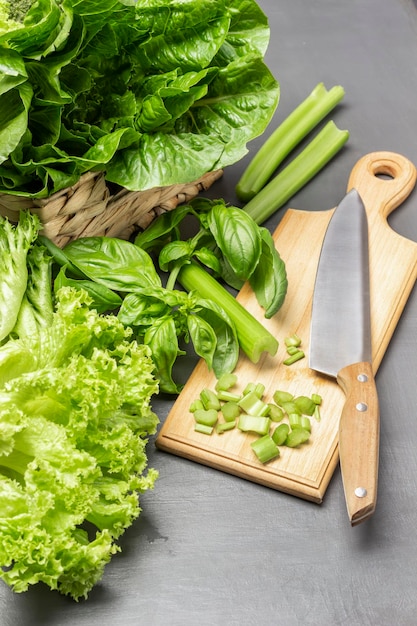 Chopped celery stalks kitchen knife on cutting board Lettuce leaves in wicker basket