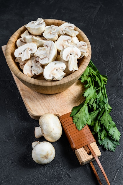 Photo chopped champignons in a wooden bowl.