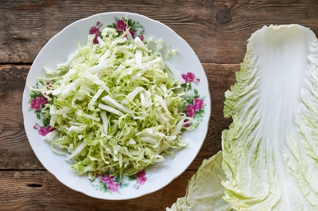 Chopped chinese cabbage in a bowl on a wood