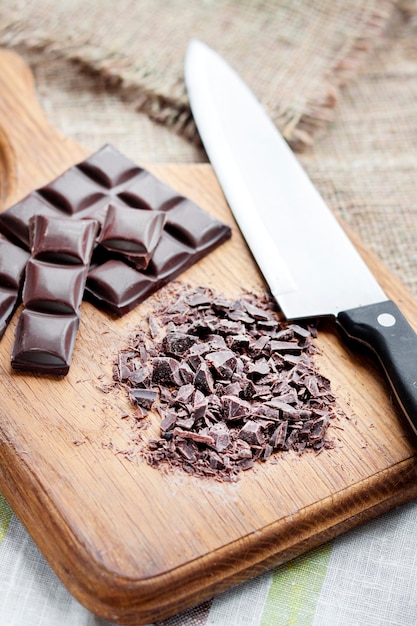 Chopped dark chocolate on wooden cutting board