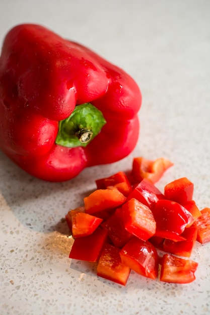 Нарезанный кубиками красный сладкий перец, сырой овощной ингредиент для приготовления пищи