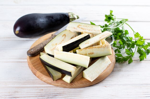 Chopped eggplant and knife on cutting board on table