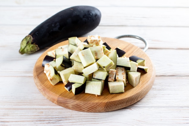 Chopped eggplant and knife on cutting board on table