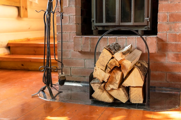 Chopped firewood stacked in woodpile against background of fireplace