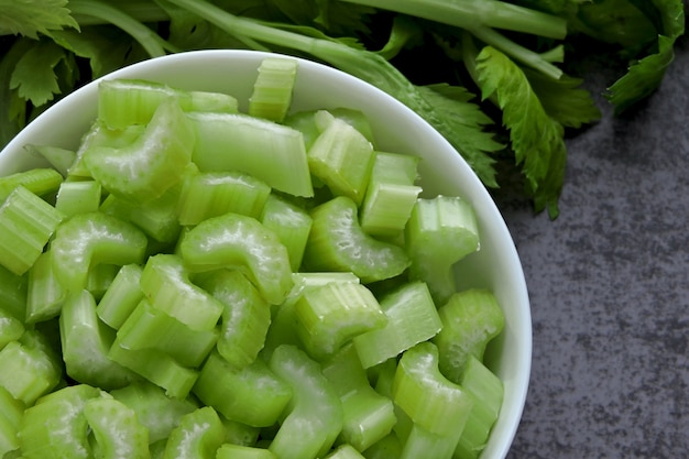 Chopped fresh celery stalks in a bowl. Top view.