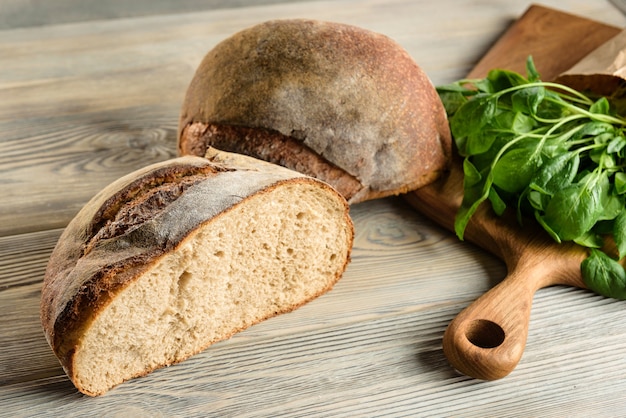 A chopped loaf of dark bread and spinach.