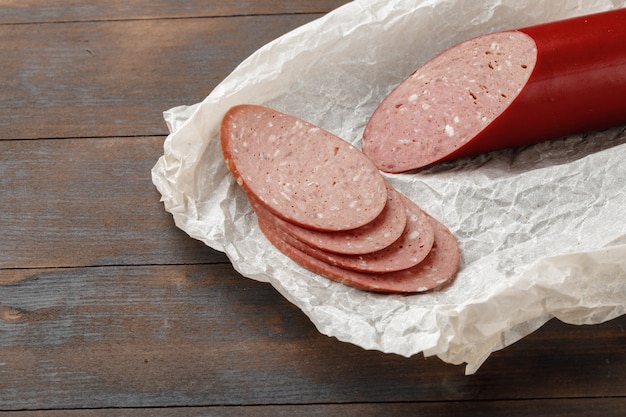 Chopped meat sausage on wooden board close up