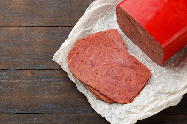 Chopped meat sausage on wooden board close up