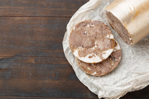 Chopped meat sausage on wooden board close up