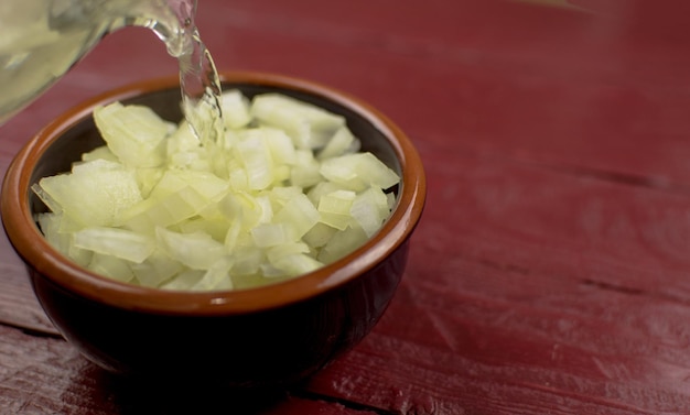 The chopped onion in a cup is filled with boiling water