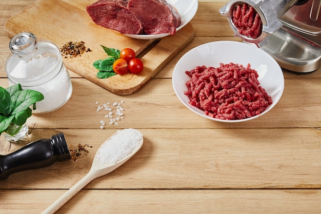 Chopped raw meat and ground beef . The process of preparing forcemeat by a meat grinder. Top view.