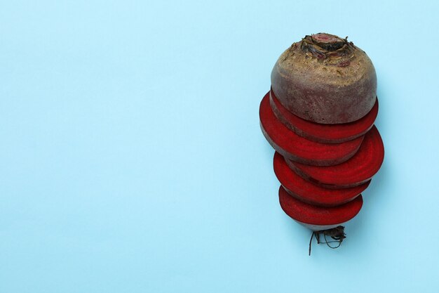 Photo chopped ripe red beet on blue background