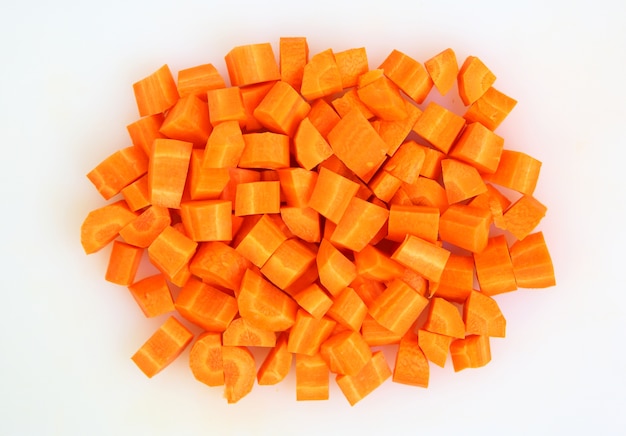 Нарезанная и нарезанная морковь на белой тарелке