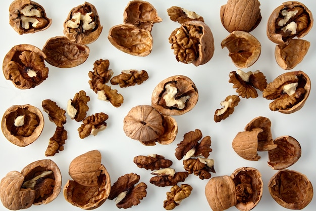 Chopped walnuts and shells on a white background