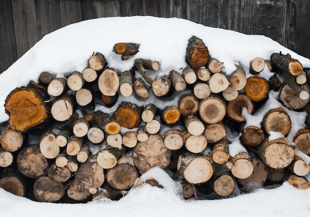 Chopped wood. Pile of wooden logs outdoor in snow