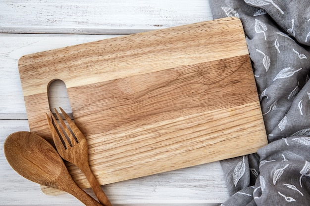  chopping board and tablecloth with the wooden fork and spoon on white table