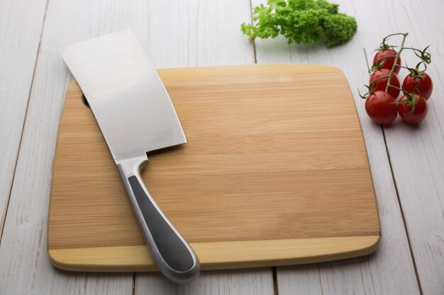 Photo chopping board with large knife and ingredients