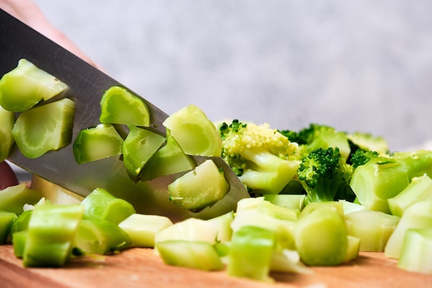 Chopping broccoli on a cutting board.