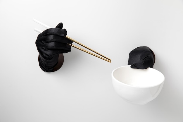 Chopstick and bowl hold with glove on white background