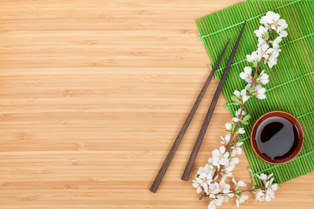 Chopsticks sakura branch soy sauce and bamboo mat