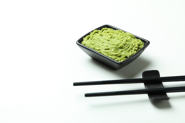 Photo chopsticks and wasabi sauce on white