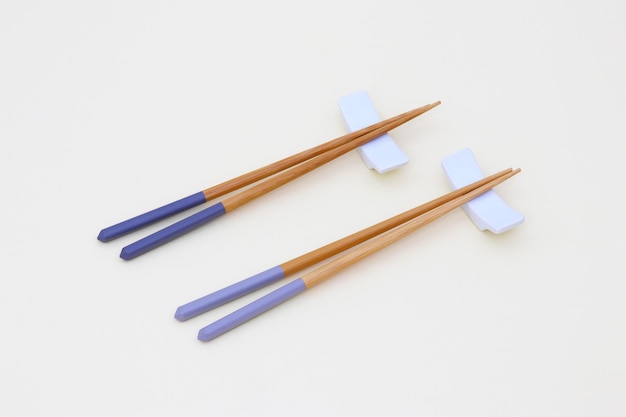 Фото Палочки для еды с синими ручками и пара палочек для еды.