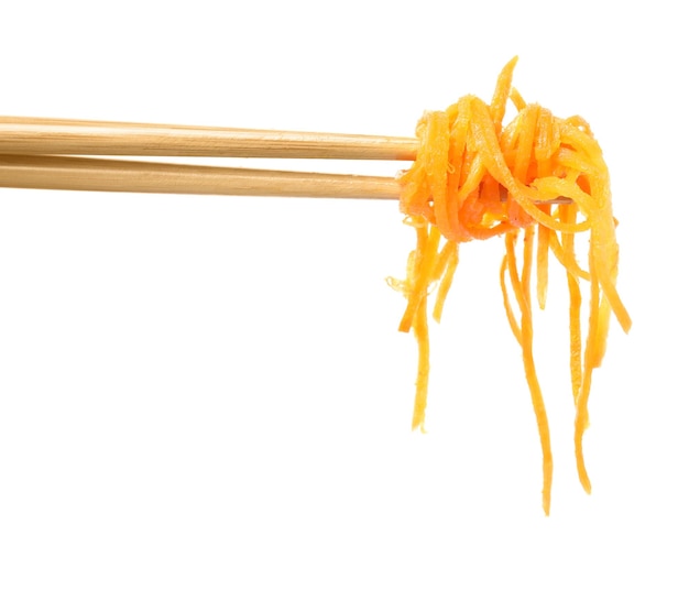 Chopsticks with delicious Korean carrot salad on white background