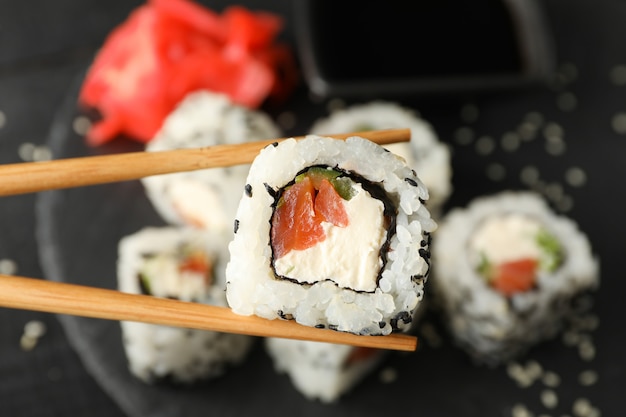 Chopsticks with delicious sushi roll. Japanese food