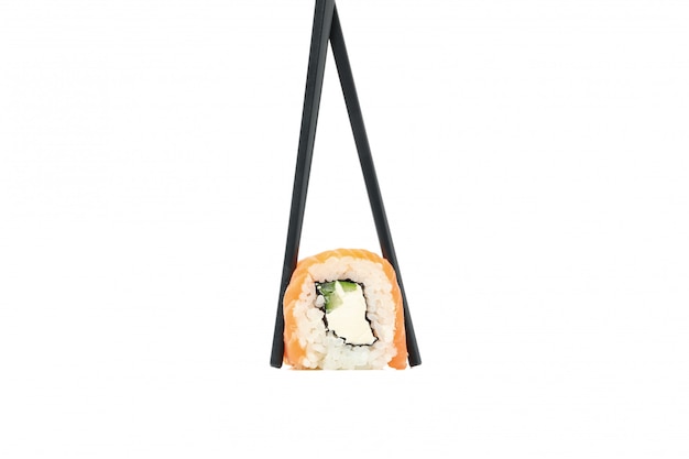 Chopsticks with sushi roll isolated