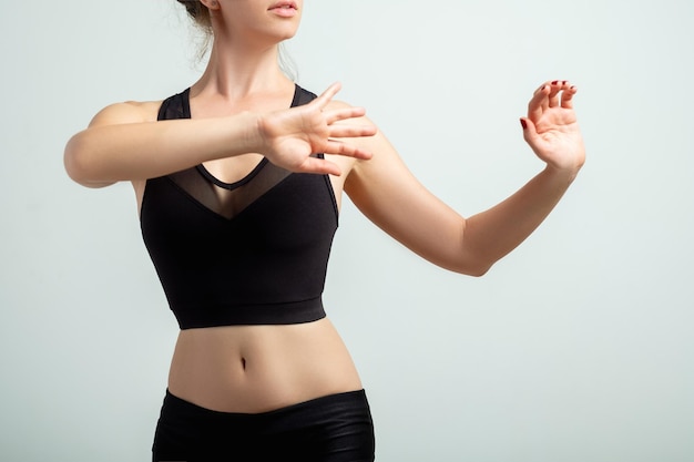 Choreografie les. Actieve levensstijl. Balletschool. Vrouwelijke sportkleding. Sierlijke vrouw met slank lichaam in zwarte mesh crop top dansen geïsoleerd op neutrale achtergrond.