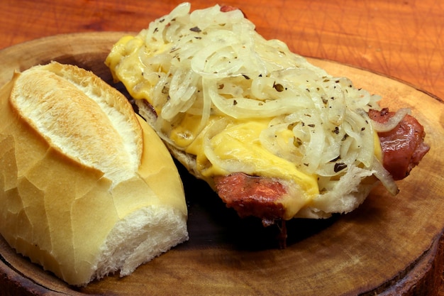 Сэндвич с колбасой choripan calabrian с сыром и луком на деревянном фоне